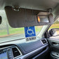 Visor mounted handical parking placard holder.  Clips to visor, and magnetically held in off position